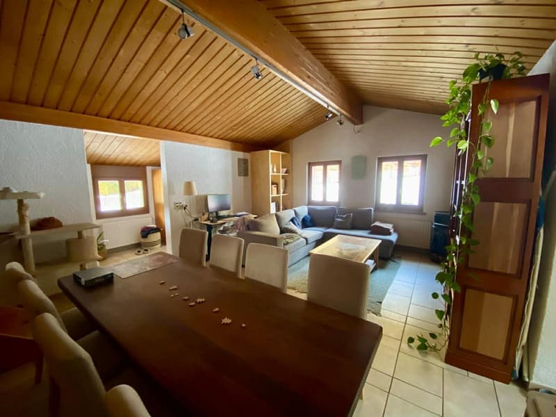 dining area with wooden table and chairs, a large window, living room with couch and coffee table, wooden ceiling, wooden floor