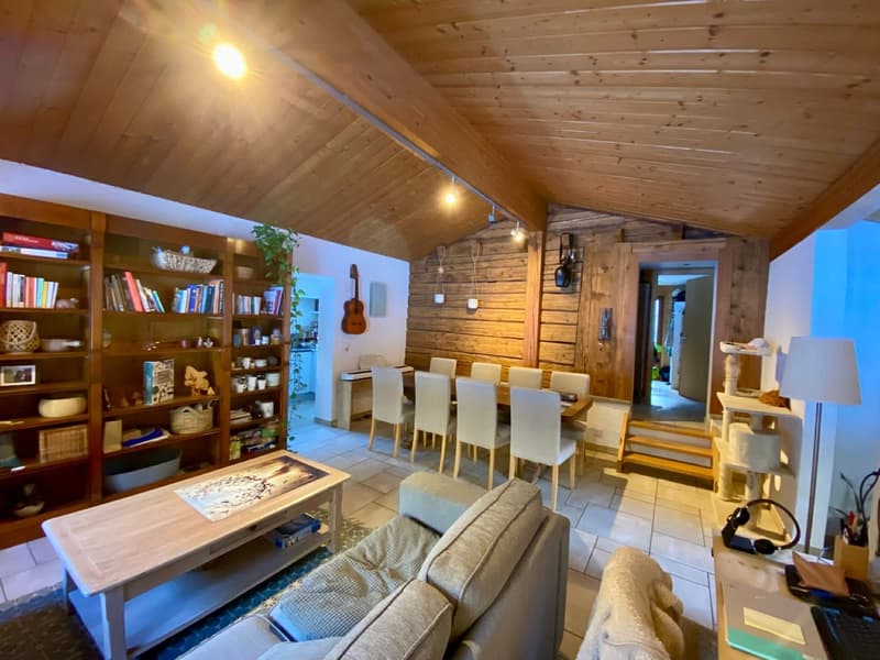 wooden ceiling, large bookshelf, dining table, 8 chairs, guitar, sofa, lamp