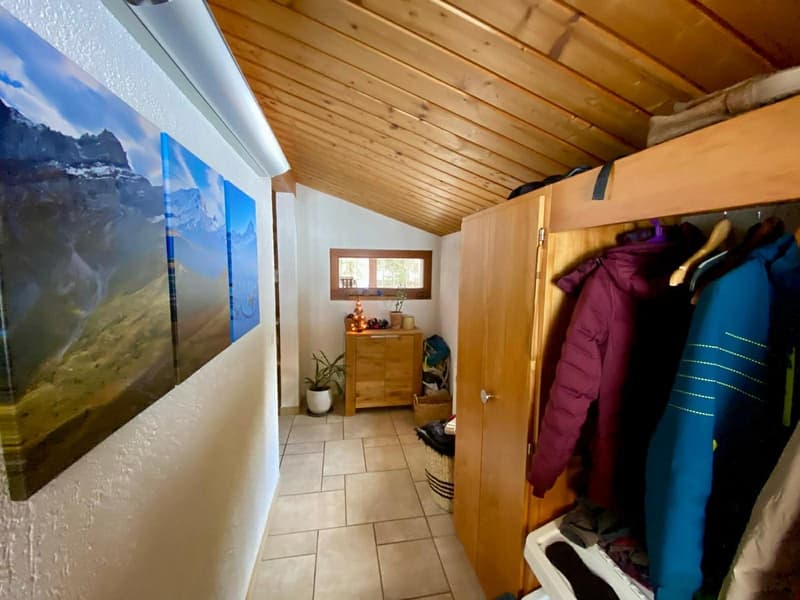 Wooden ceiling, tiled floor, wooden cabinet, hanging clothes, large painting