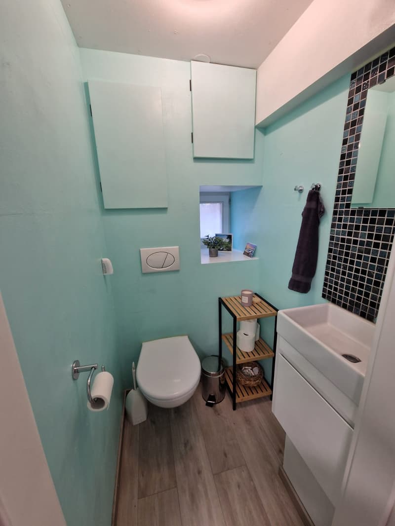 small bathroom with toilet, sink, and small window