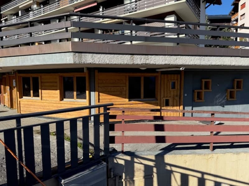 Exterior of the building with balcony, wooden doors and windows, and red railings