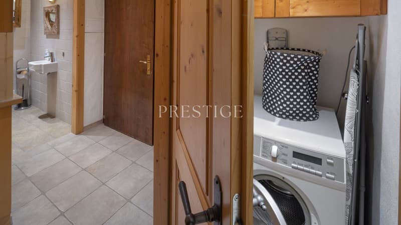 tiled floor, wooden door, washing machine, sink, mirror, wooden cabinets
