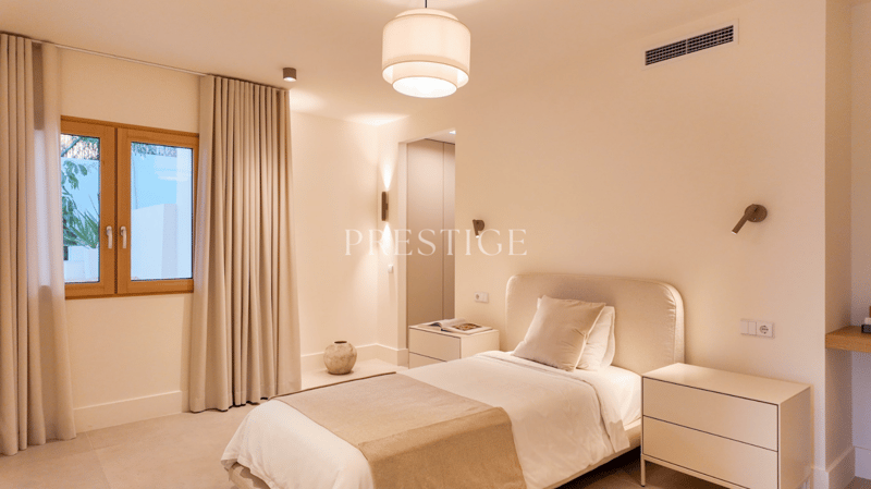 Bedroom with a bed, nightstands, and a window with curtains