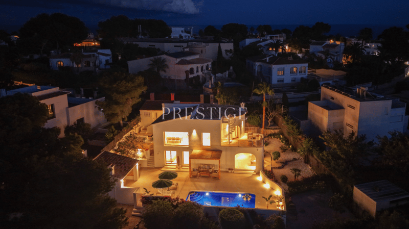 Modern villa with swimming pool, multiple windows, outdoor seating, and a spiral staircase