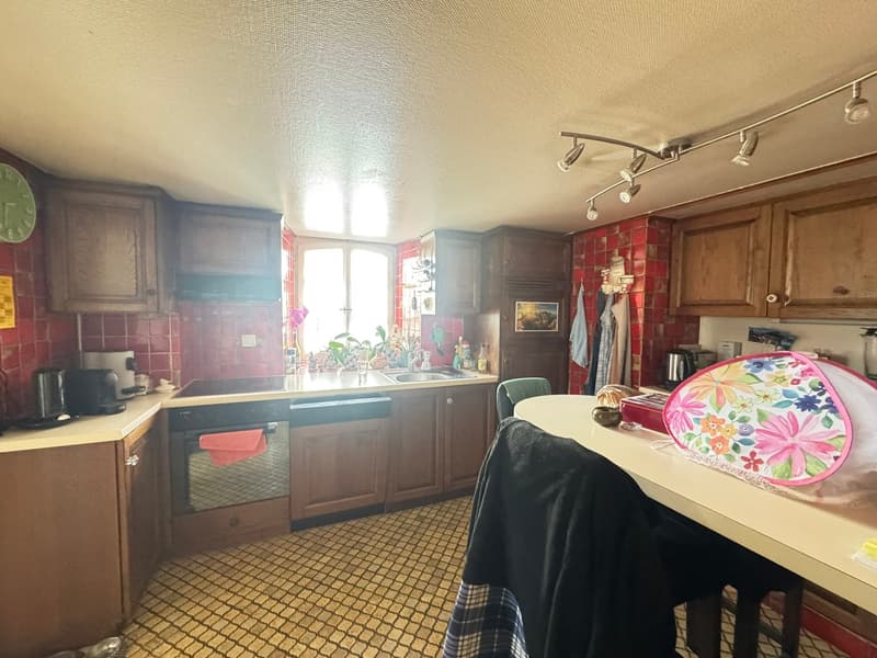 tiled floor, wooden cabinets, sink, stove, oven, microwave, coffee maker, kettle, dishes, table, chairs