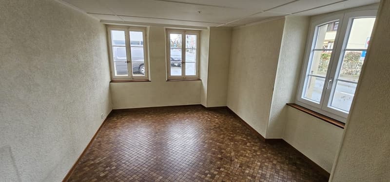 Empty room, tiled floor, three windows, two doors