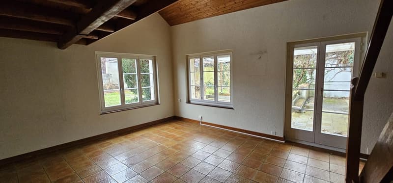 Empty room, wooden ceiling, tiled floor, two windows, double door