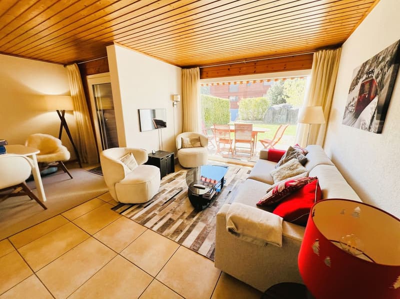 living room with couch, chairs, table, lamps, rug, mirror, and a glass door leading to a patio with outdoor furniture