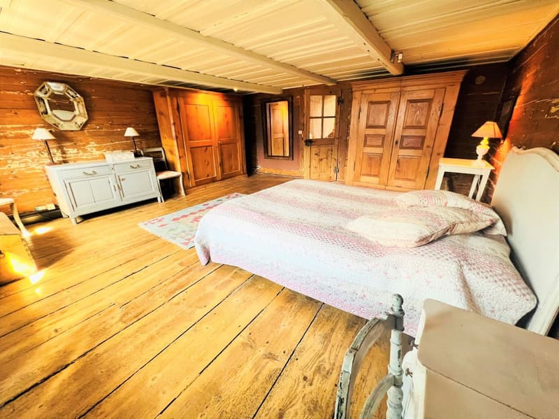 wooden floor, wooden walls, bed, wooden cabinet, lamps, rug, mirror
