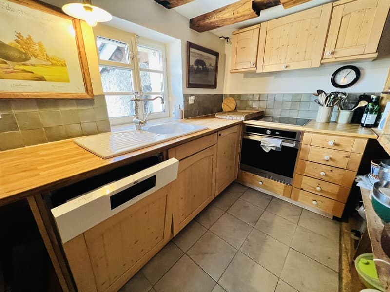 wooden cabinets, tiled floor, white sink, dishwasher, oven, wooden countertop, window