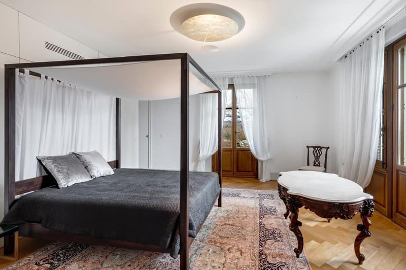 Canopy bed, wooden furniture, oriental rug, white curtains, white walls, windows