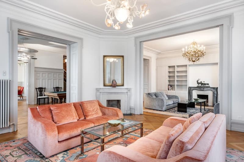 living room with pink sofas, fireplace, chandelier, coffee table, rug