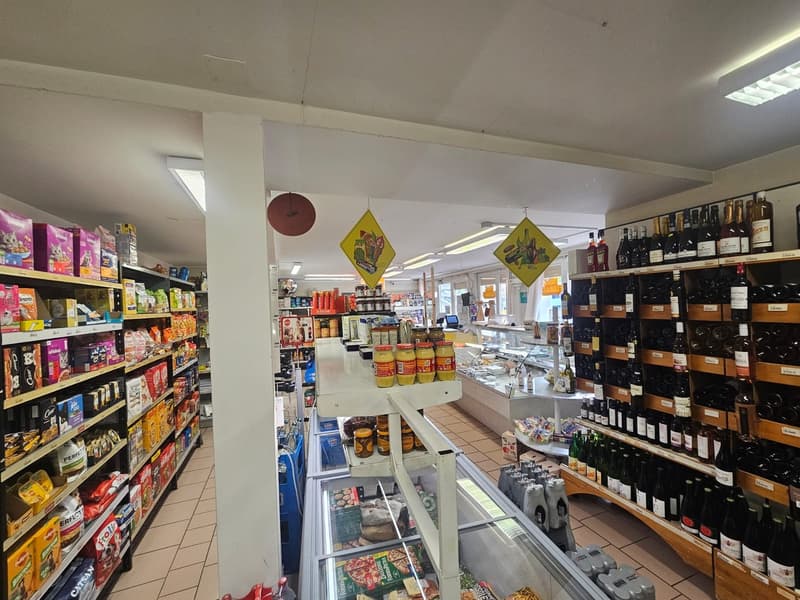 A grocery store with various products on shelves, including snacks, beverages, and condiments. There are also bottles of wine on the shelves.