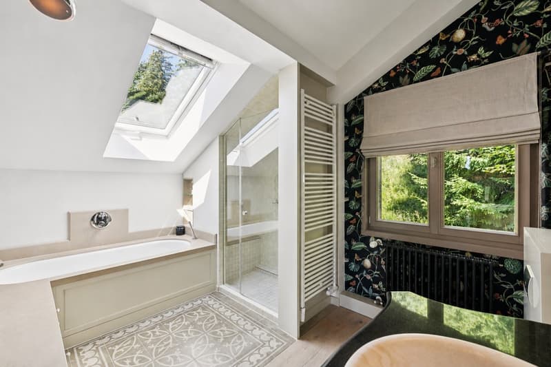 Grande salle de bains attenante à la suite parentale, équipée d'une baignoire et d'une douche pour un confort optimal.