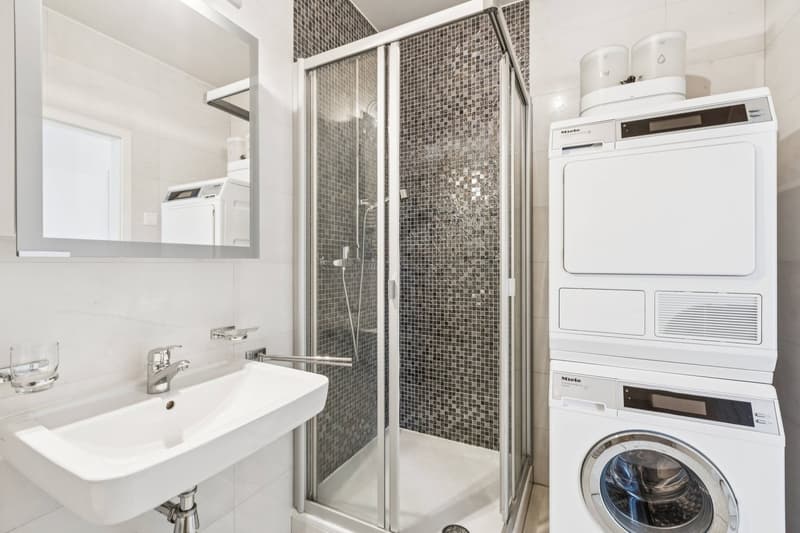 Une salle de douche avec espace buanderie