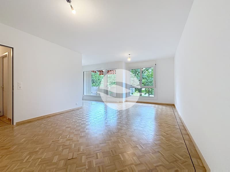 Spacieux séjour avec parquet mosaïque entouré d'une frise