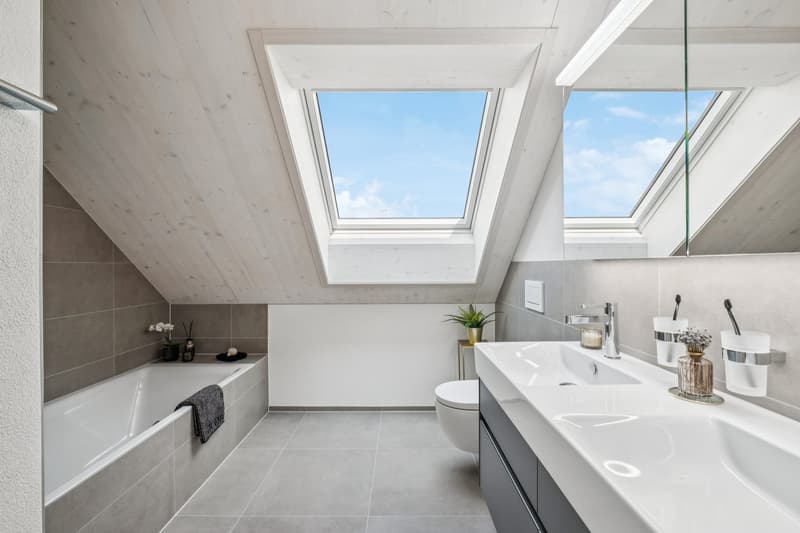 Grosszügige Nasszelle mit Badewanne und modernem Dusch-WC (Geberit AquaClean Alba)