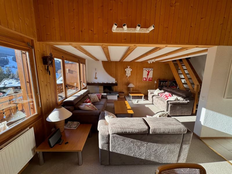 wooden walls, fireplace, large windows, sofa, coffee table, lamps