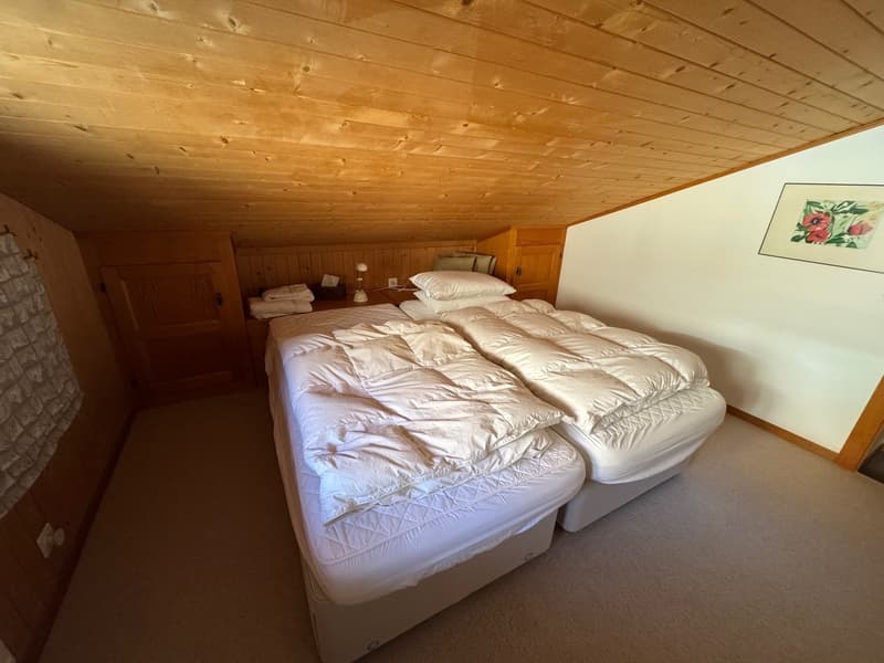 Bedroom with two beds, pillow, blanket, nightstand, lamp, picture frame, wooden cabinet, bedspread