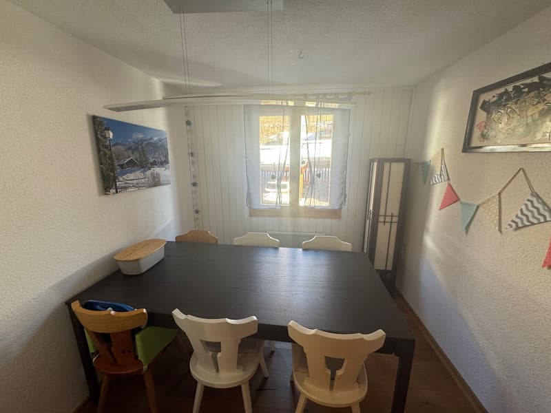 large dining table, wooden chairs, window, picture frame, wall decorations, radiator