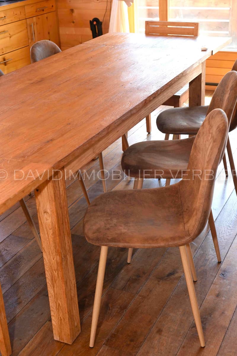 a long dining table with six chairs around it, wooden floors