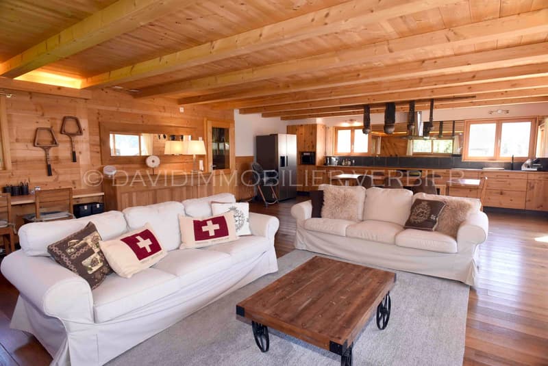 large living room with 2 couches, a center table, kitchen, dining table, kitchen island with stools