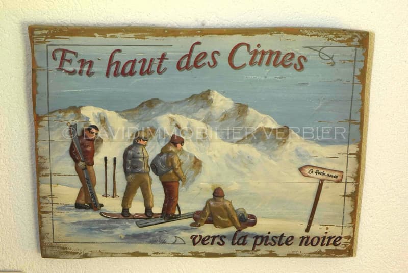 A vintage painting of people snowboarding in the mountains with the words 'En haut des Cimes'.