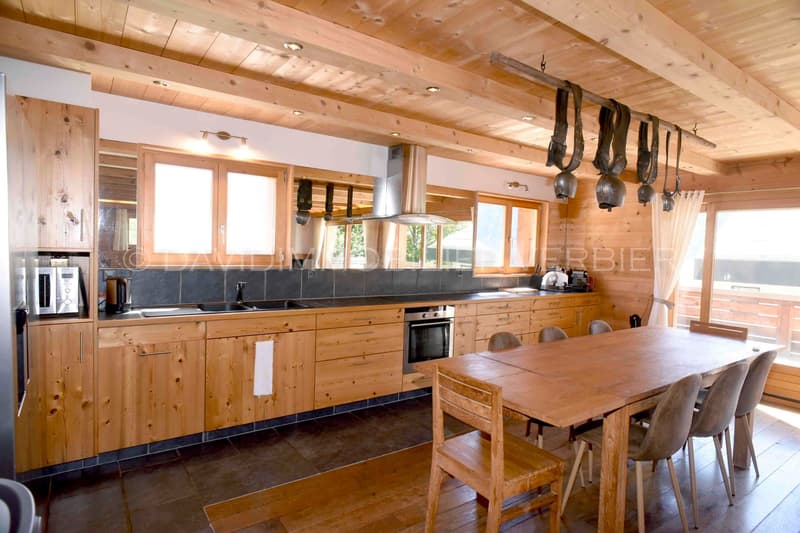 wooden ceiling, wooden floor, wooden table, wooden chairs, kitchen with oven, microwave, sink