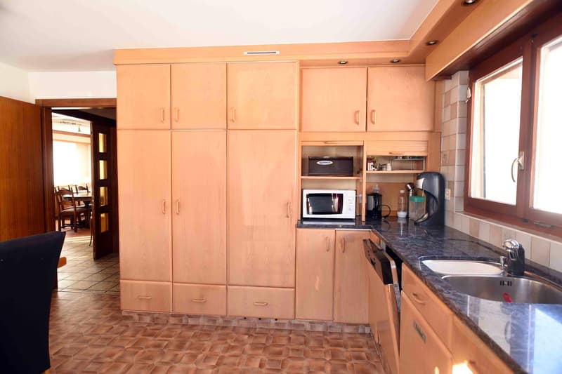 kitchen with wooden cabinets, stainless steel sink, countertop, dishwasher, microwave, coffee maker, and countertop
