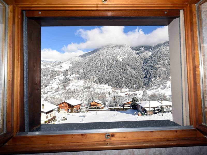 View from the window: snowy mountain landscape with several chalets