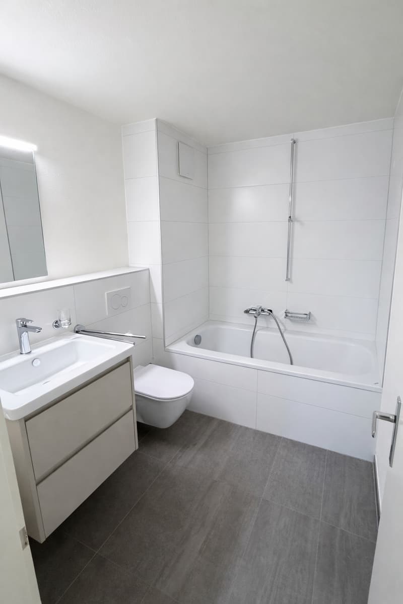 Bathroom: white tiles, white bathtub, white sink, white toilet, white mirrors, shower, modern fixtures