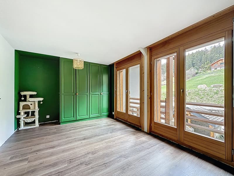 empty room, wooden floor, green walls, wooden doors, large windows, balcony