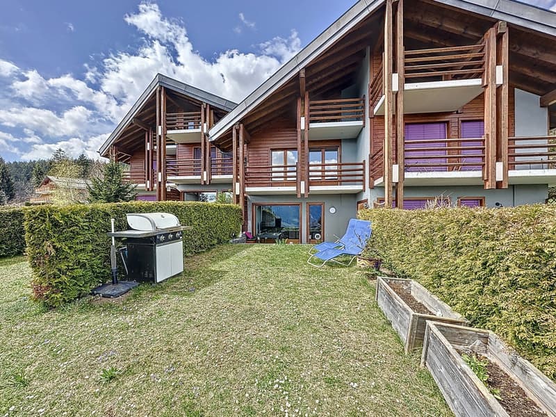 Multistory building with wooden exterior, terraces on multiple levels, outdoor grill, wooden storage boxes