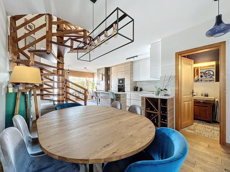 spiral staircase, wooden dining table, round wooden floor, lamp, wooden chair, kitchen, microwave, wine cabinet