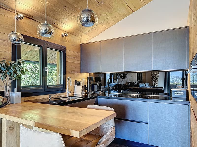 Wooden counters, wooden walls, large windows, modern kitchen appliances, sink, stove, refrigerator