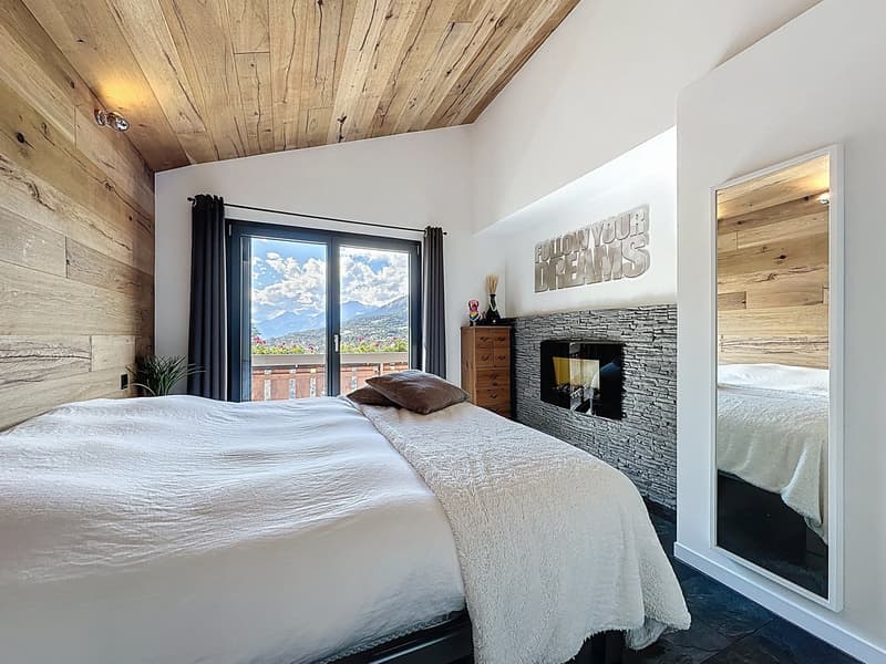 bedroom with double bed, fireplace, large windows, view of the mountains
