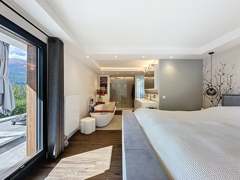 bedroom with bathtub, large window with balcony, modern interior design, wooden floor, grey bed, bathtub in the bathroom