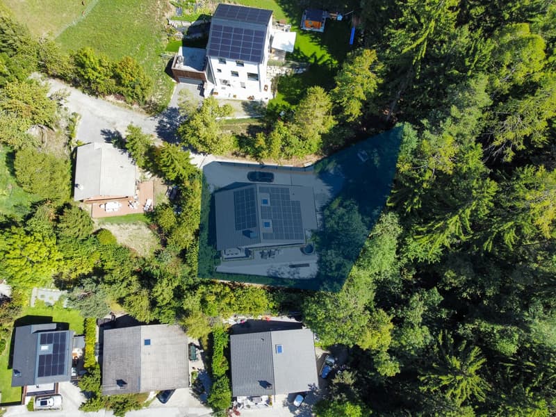 Solar panels on roof, balcony, surrounded by trees