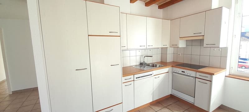 Modern kitchen with white cabinets, stainless steel appliances, wooden countertops, tiled backsplash, sink, dishwasher, oven