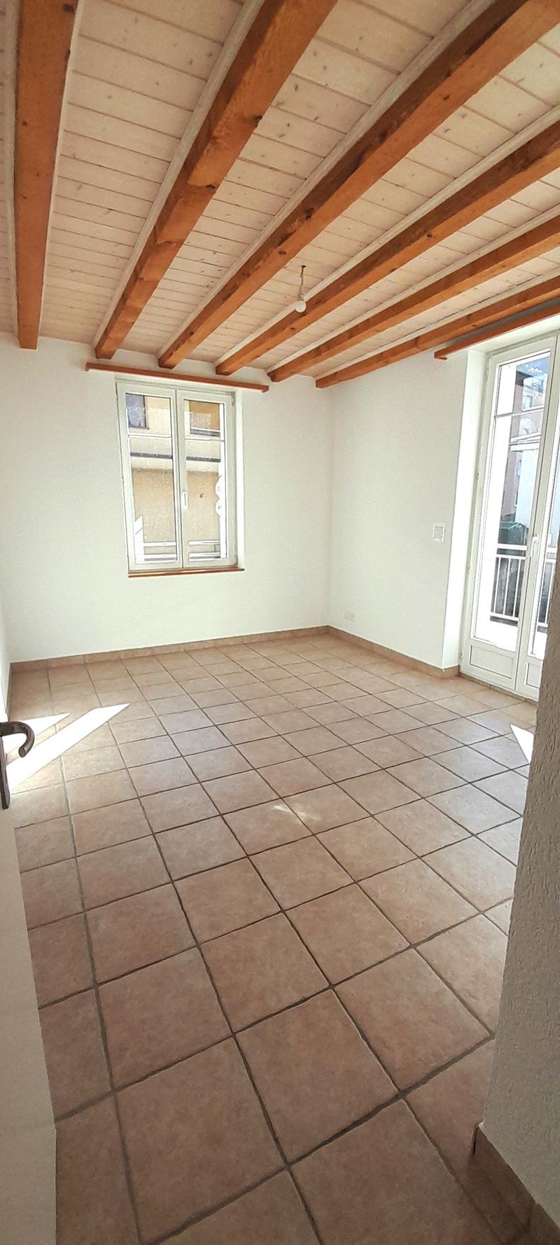 empty room, wooden ceiling, tiled floor, large windows, balcony