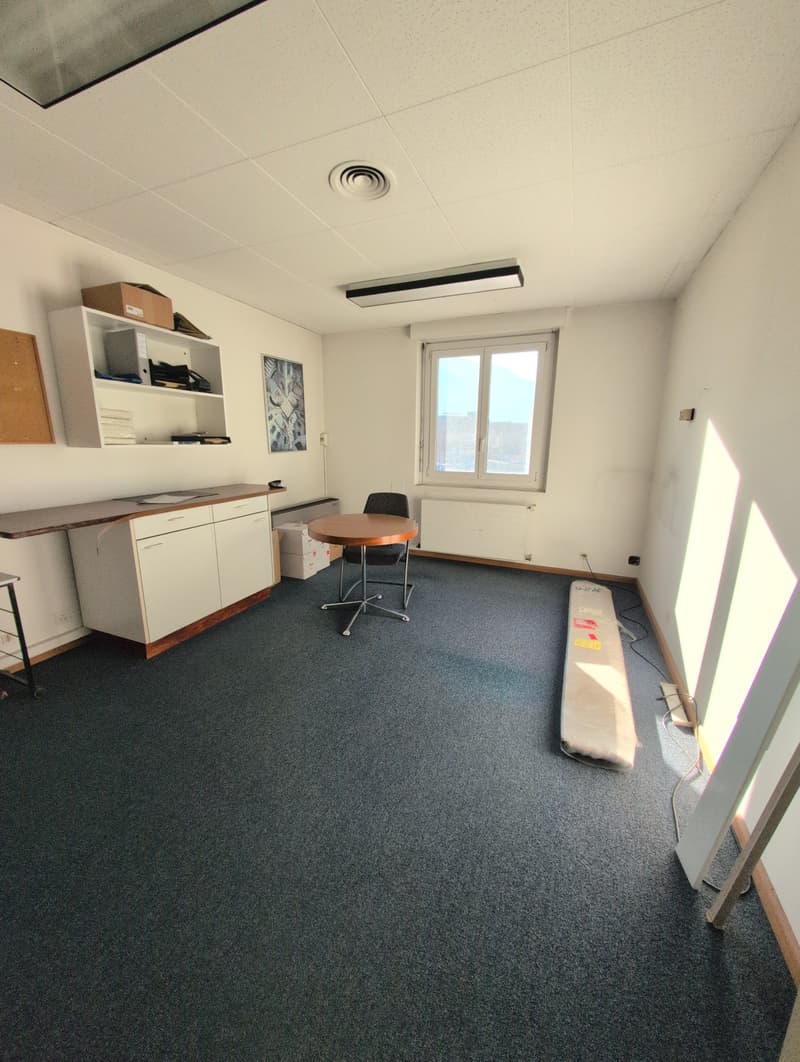 empty office room with one window, wooden floor, wooden desk, two chairs, a radiator