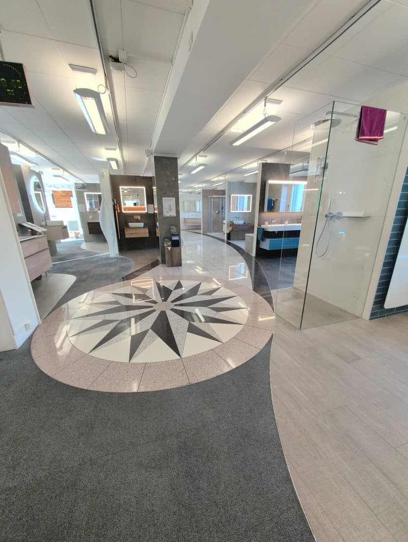Bathroom showroom with large tile floor design, modern sinks, and shower glass walls
