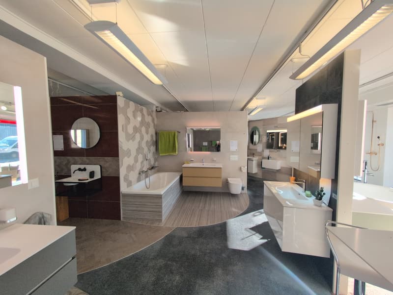 modern bathroom with a bathtub, double sinks, white cabinets, and green towel on a towel rack