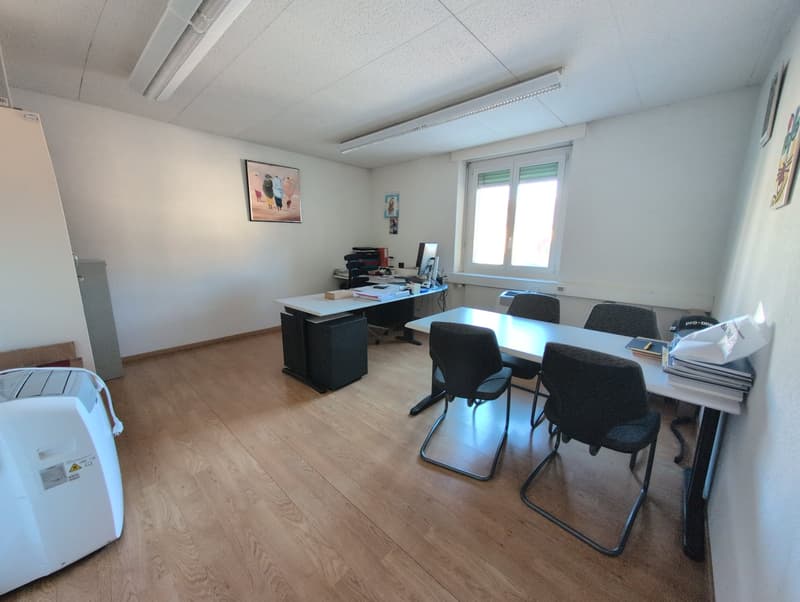conference room with wooden floor, white walls, two desks, six chairs, a monitor, and a cabinet