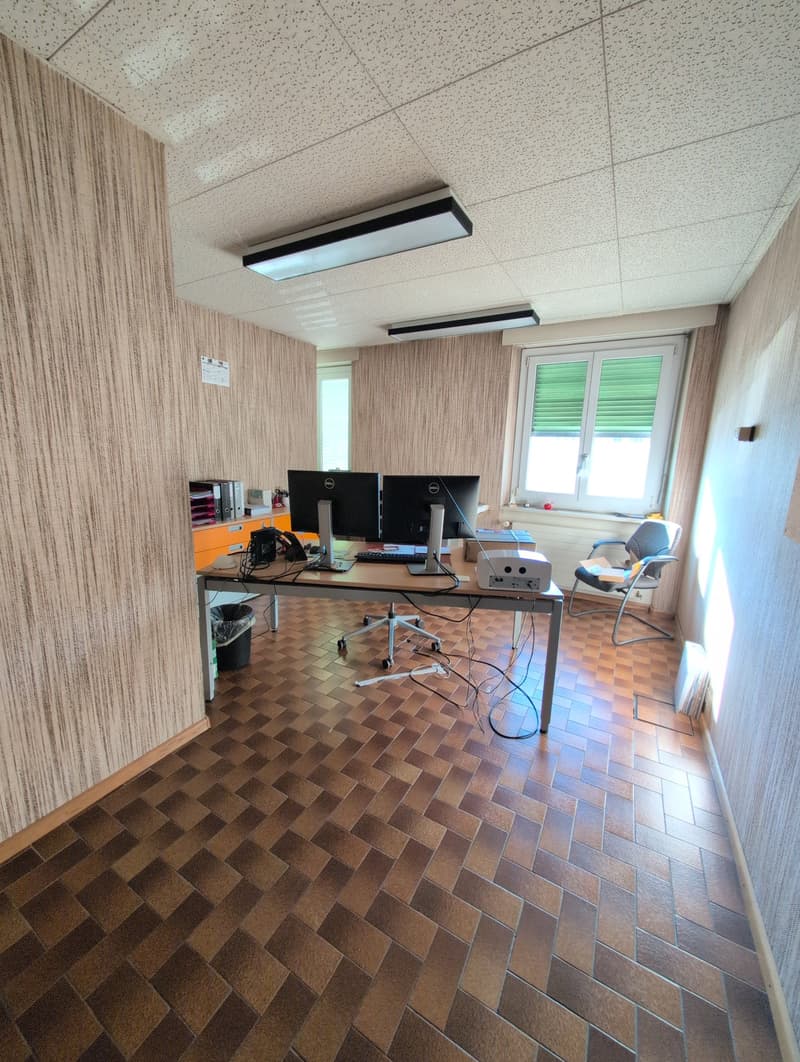 tiled floor, office desk with computer, keyboard and projector, office chair, office supplies on cabinet