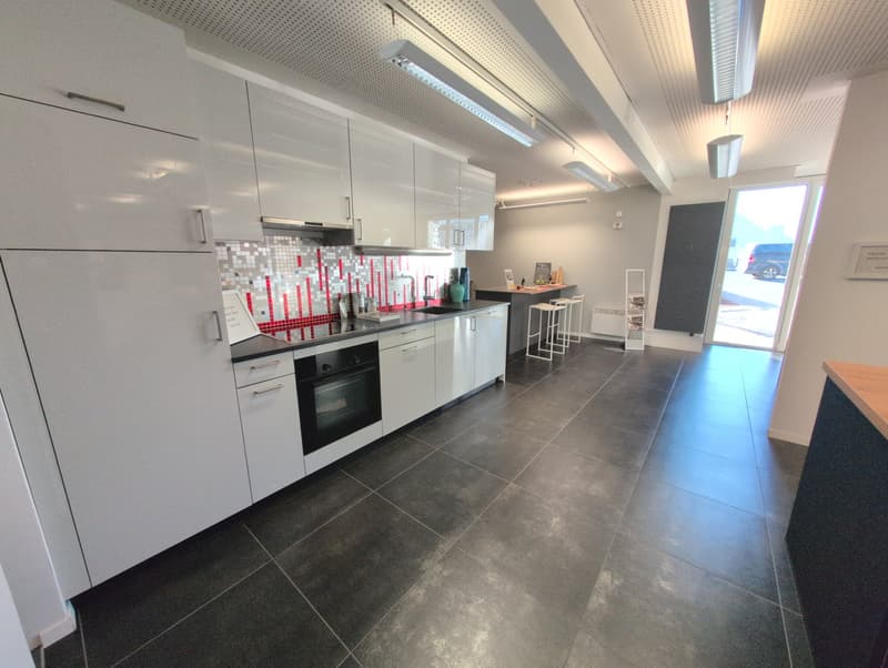 modern kitchen with white cabinets, black tiled floor, electric oven, undercounter fridge, sink, large window