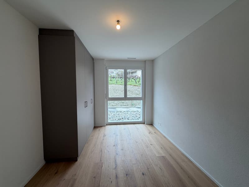 empty room, wooden floor, white walls, large window, built-in wardrobe