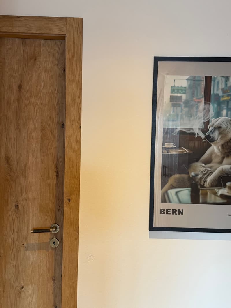 wooden door, white wall, picture frame with Bern image