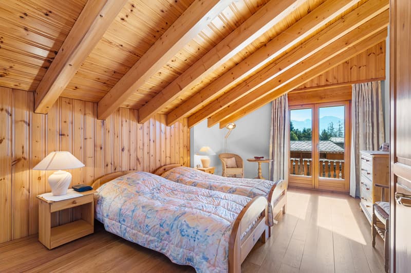 / a bedroom with a large bed and a wooden ceiling