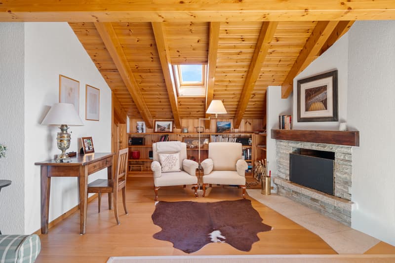 / a room in a home with a fireplace and wooden ceilings